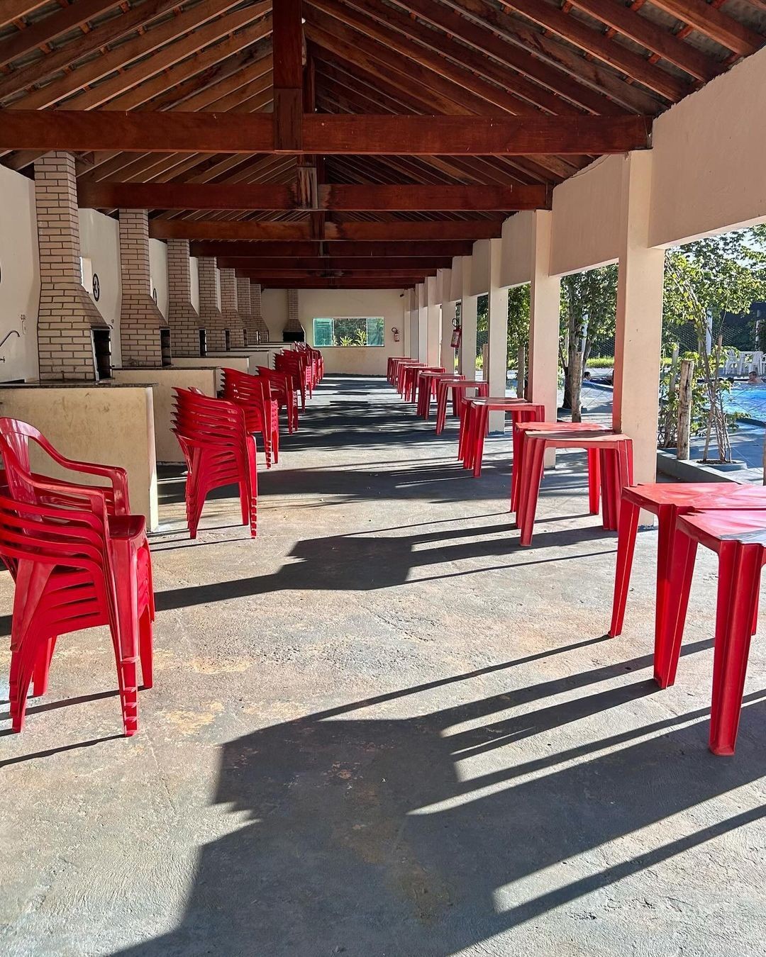 Espaço com churrasqueiras ao ar livre, prontas para uso. Equipadas com mesas e cadeiras, é o local ideal para reuniões familiares e confraternizações, com vista para a área de lazer do clube